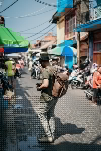 Tourist holding a camera in a street market.